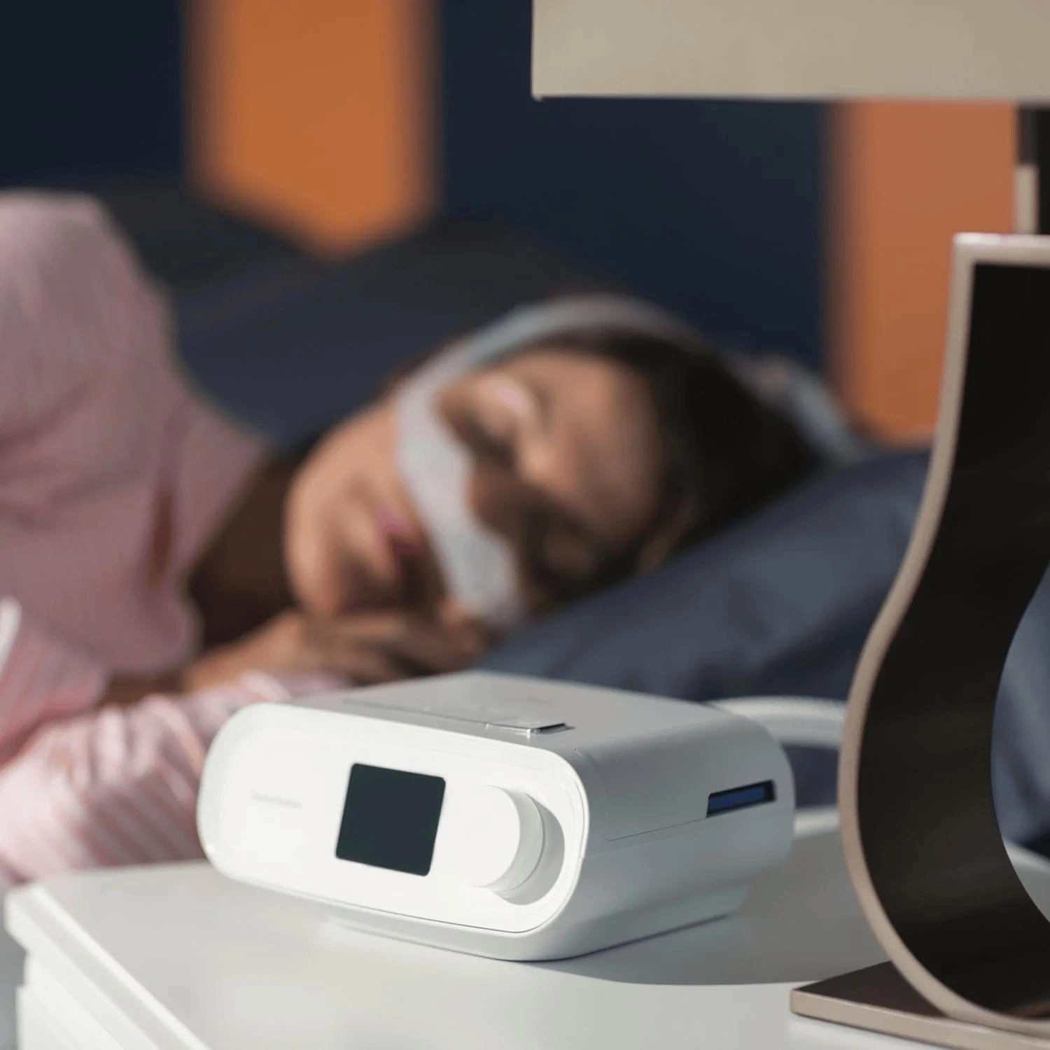 DreamStation Auto CPAP Machine on a bedside table during overnight use