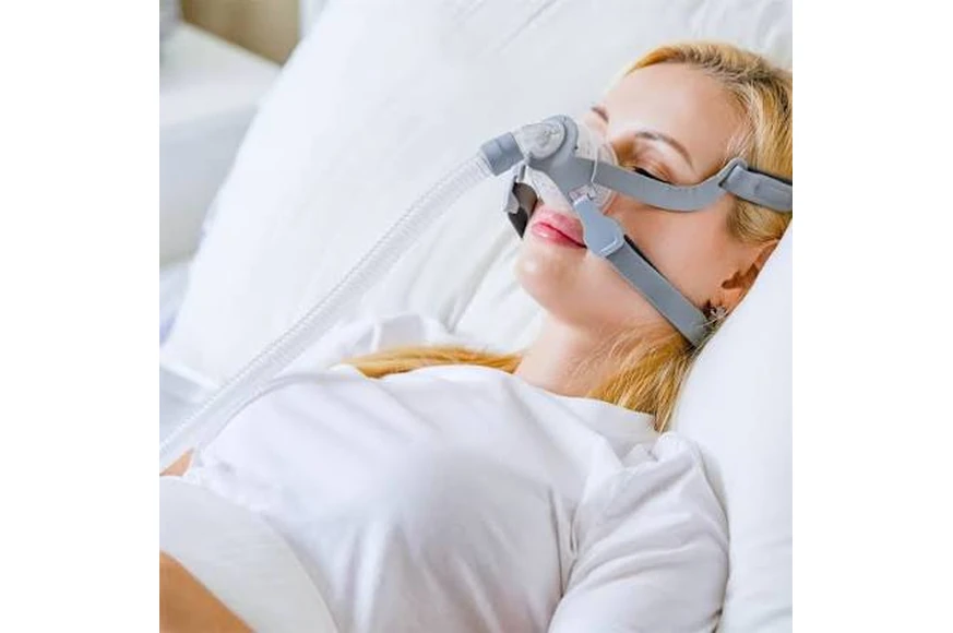 Woman wearing BMC N5B nasal mask, lifestyle shot in bed