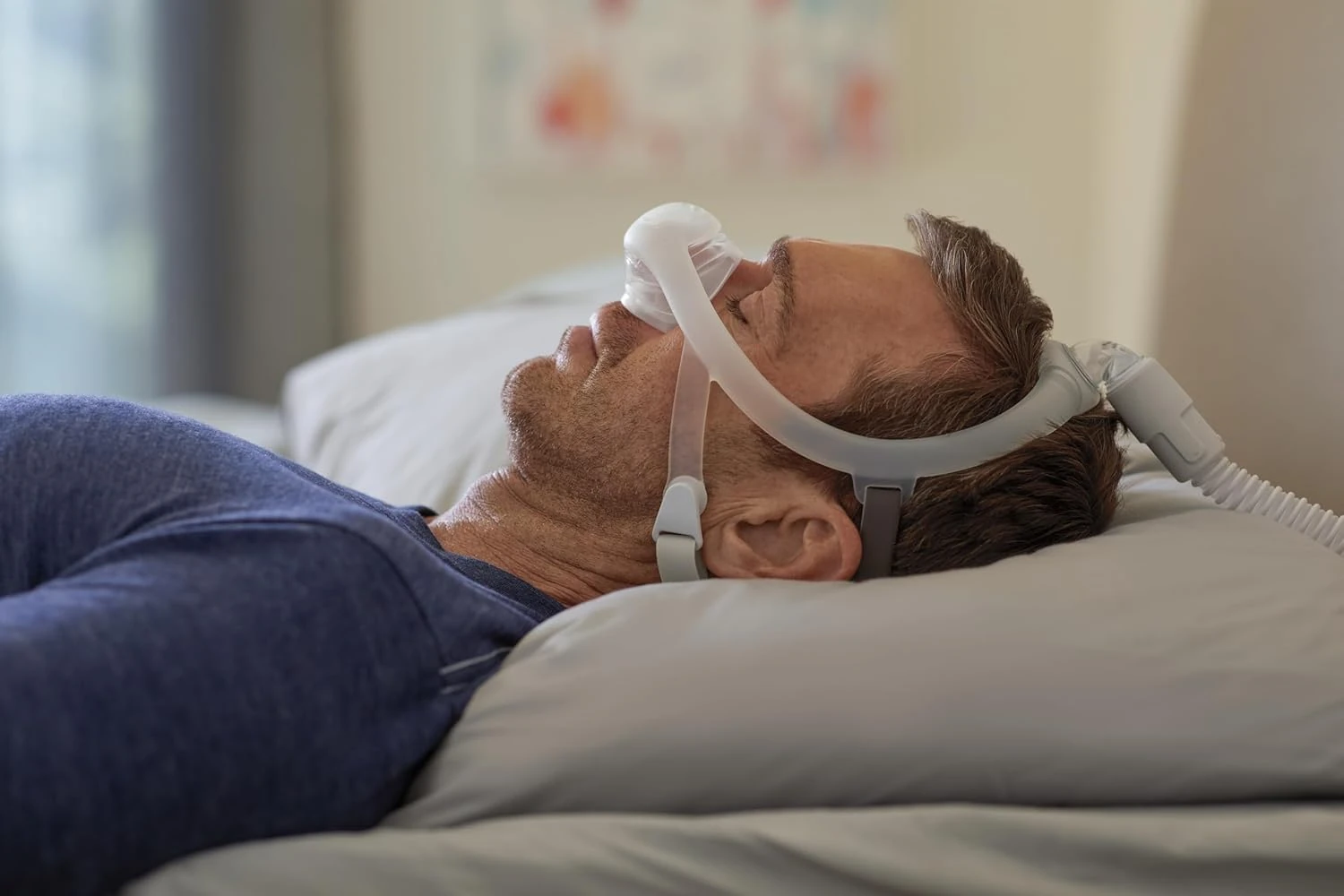 Man wearing Philips Wisp Nasal Mask, sleeping, lifestyle shot
