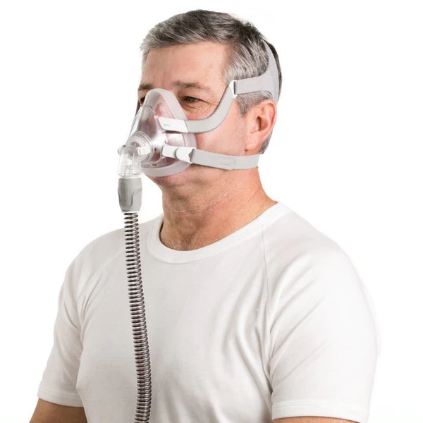 Man wearing ResMed AirFit F20 full face mask, front-angled side view, white t-shirt, white background