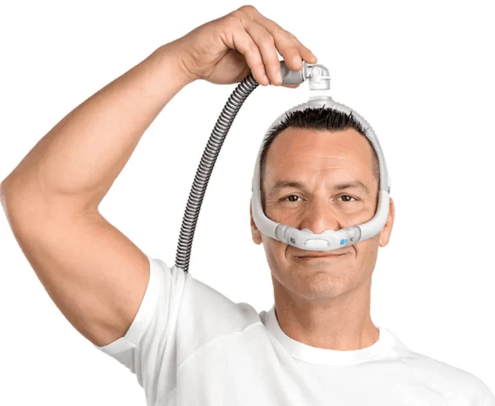 Man wearing the ResMed AirFit P30i nasal pillow mask with top-of-head tubing